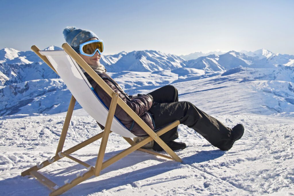 A woman relaxes at the summit of a mountain