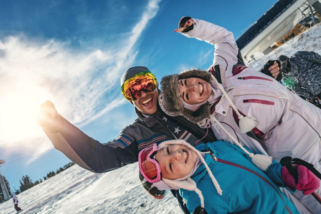 A happy family goes skiing at family winter vacation destinations