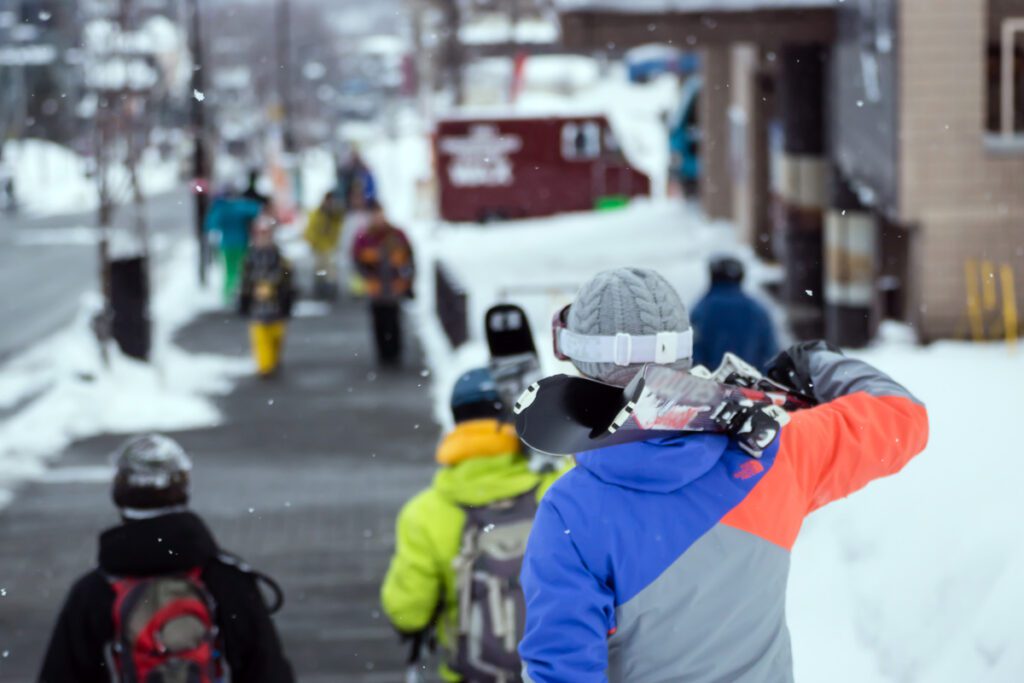 A man carries skis on his shoulder.