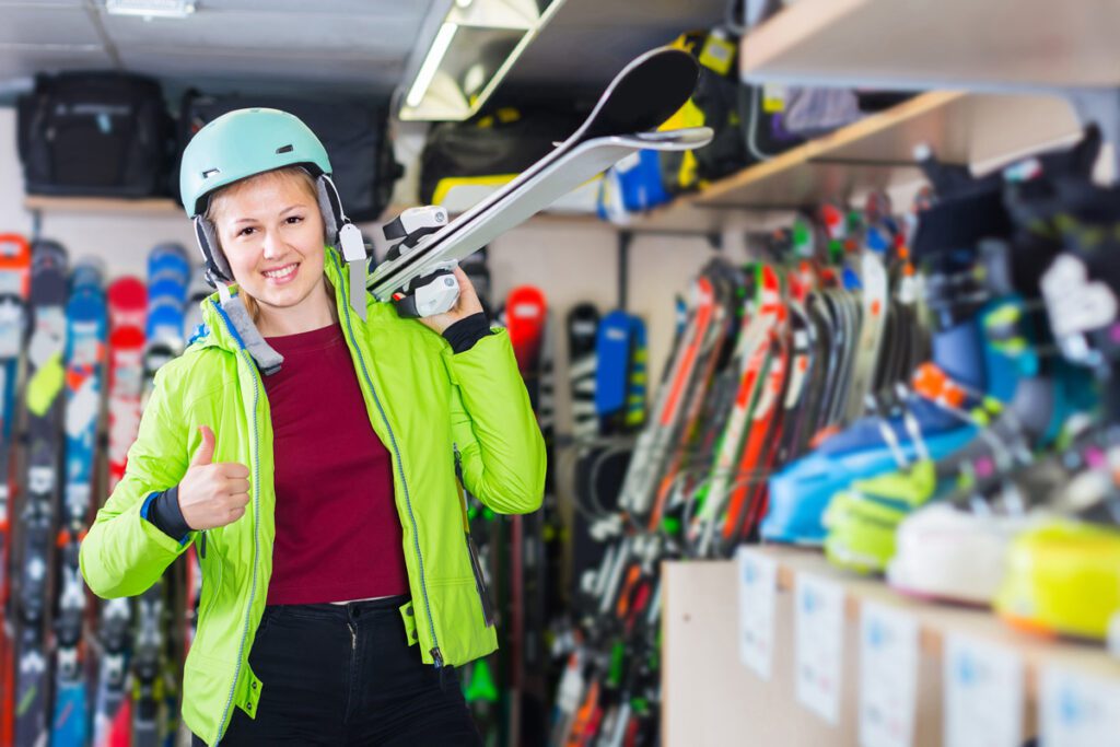 A woman rents ski gear at a mountain ski shop.