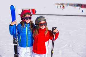 two-girls-holding-skis