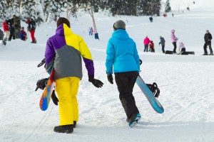 couple-with-snowboards-walking