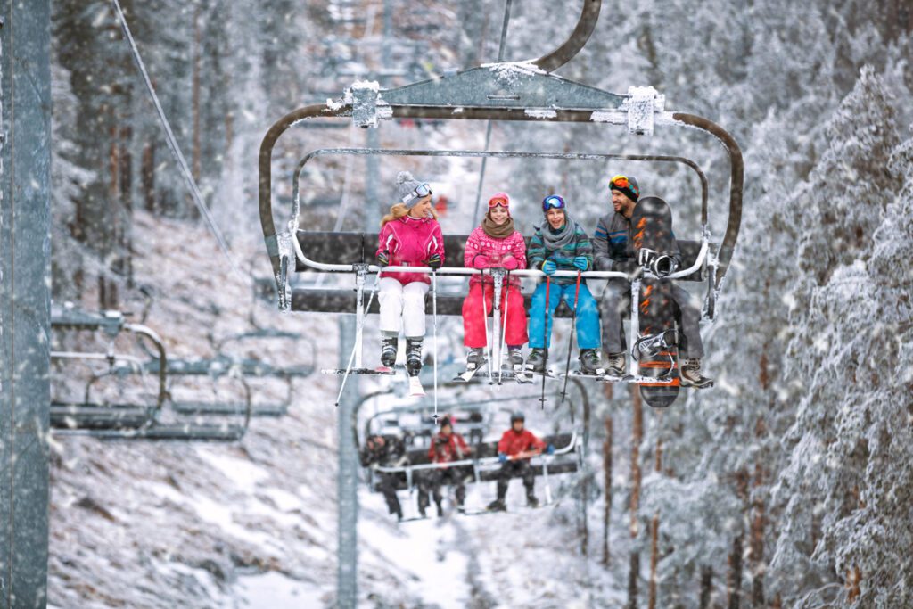 A family of four rides the ski lift