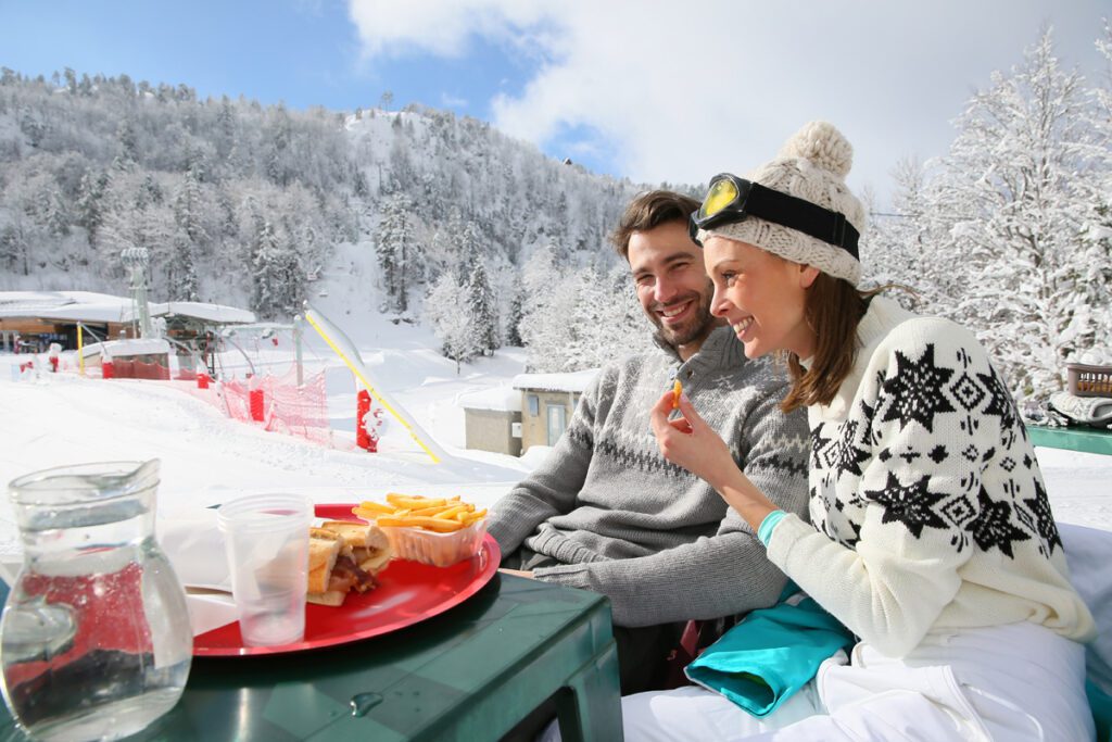 A couple enjoys lunch on the ski mountain