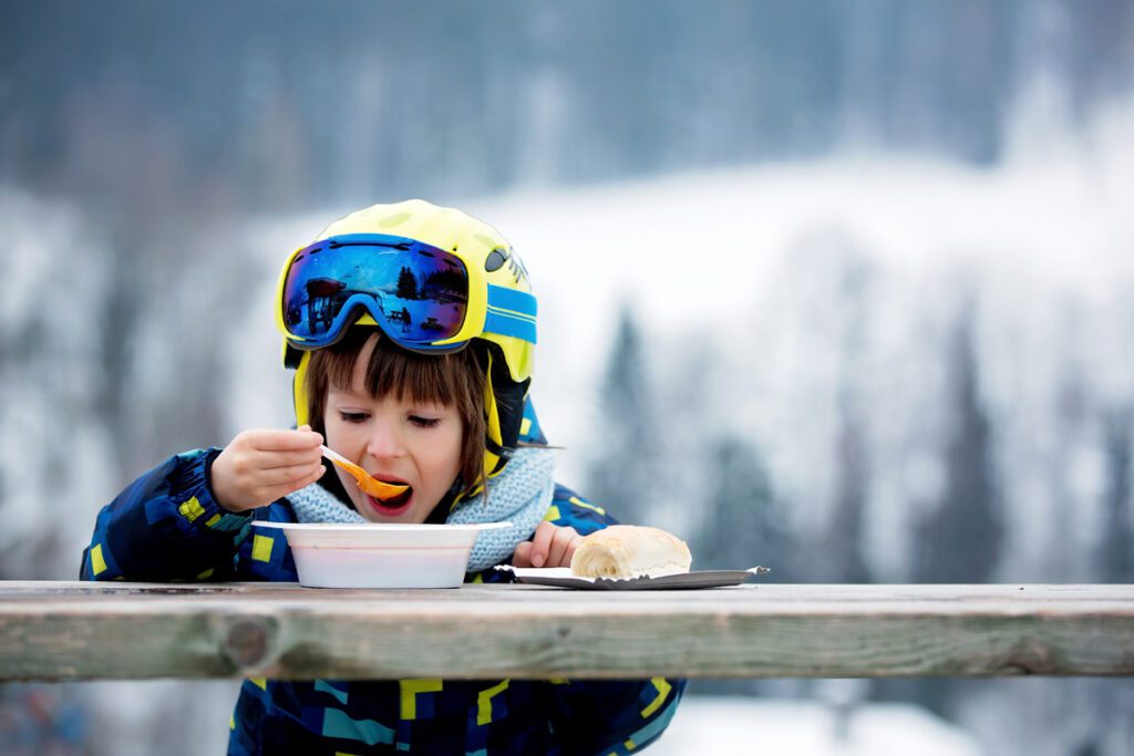 A child enjoys breakfast on the mountain