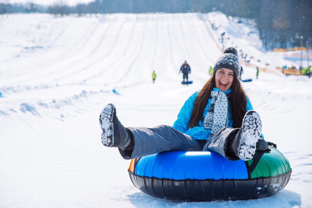 A woman enjoys snow tubing